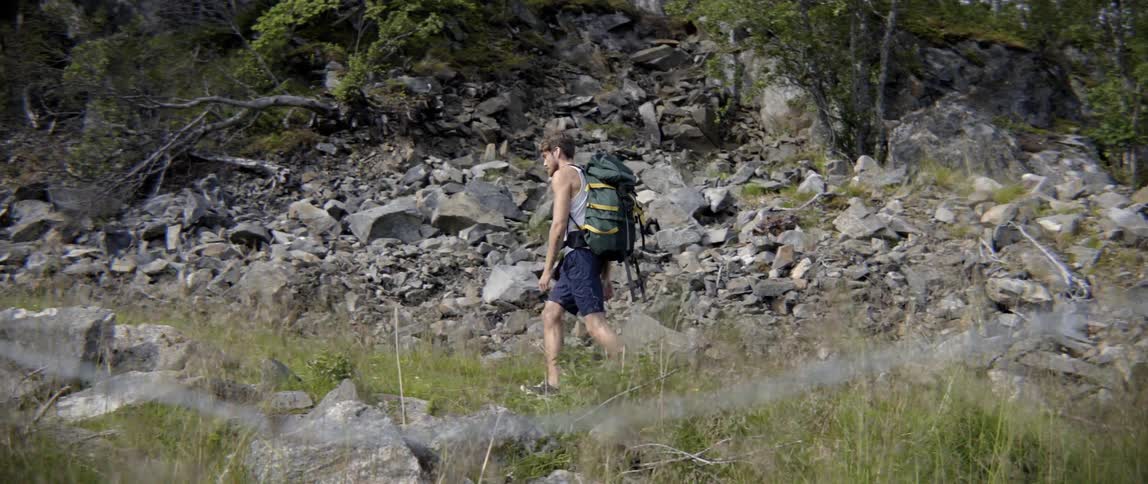 An athletic traveler pushes through fatigue to complete an intense outdoor mountain climb.