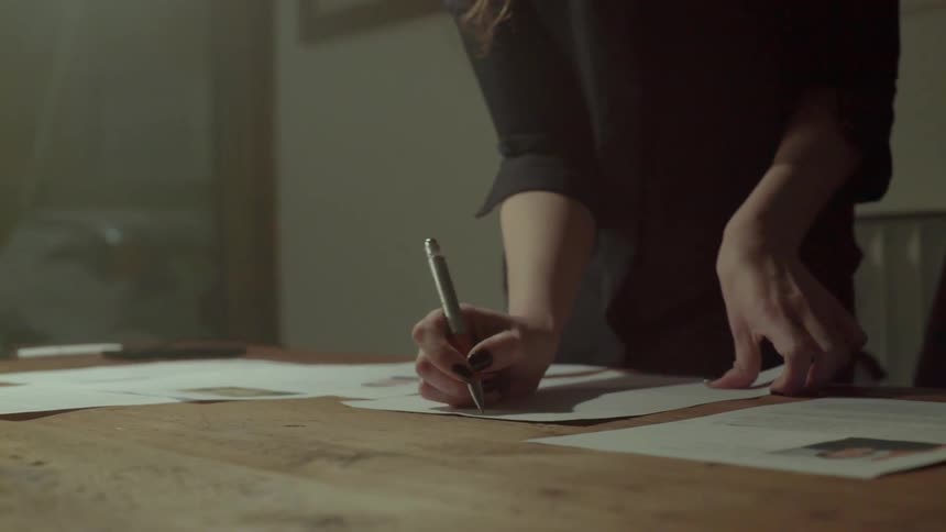 An ambitious entrepreneur takes fast notes while planning her next big business strategy indoors.