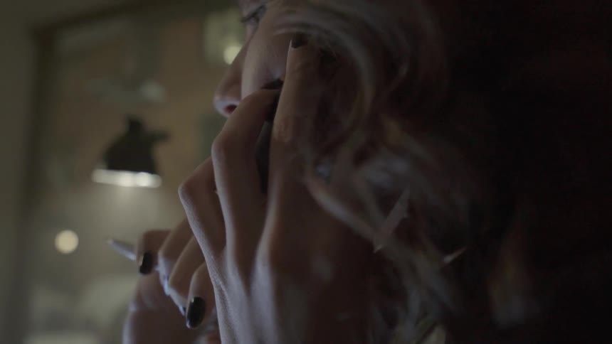 A focused consultant listens intently to a client's feedback during a nighttime phone call.