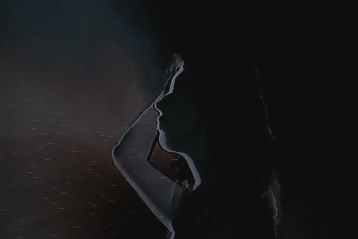 A woman brushes her hair back