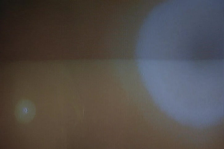 Silhouette of a woman in front of a spotlight on vhs video distortion