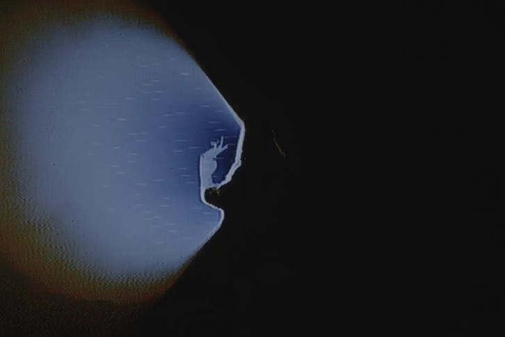 Silhouette of a woman in front of a spotlight with vhs video distortion