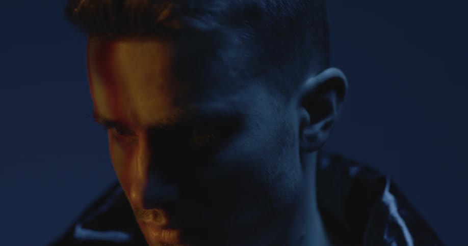 Closeup of a serious mans face in a dark environment