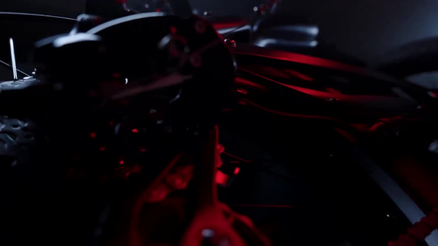 Spinning around a motorcycle parked in a dimly lit room
