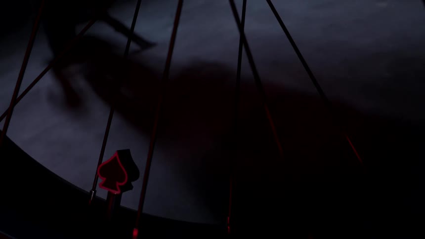 A bike wheel focused on spokes in dark lighting