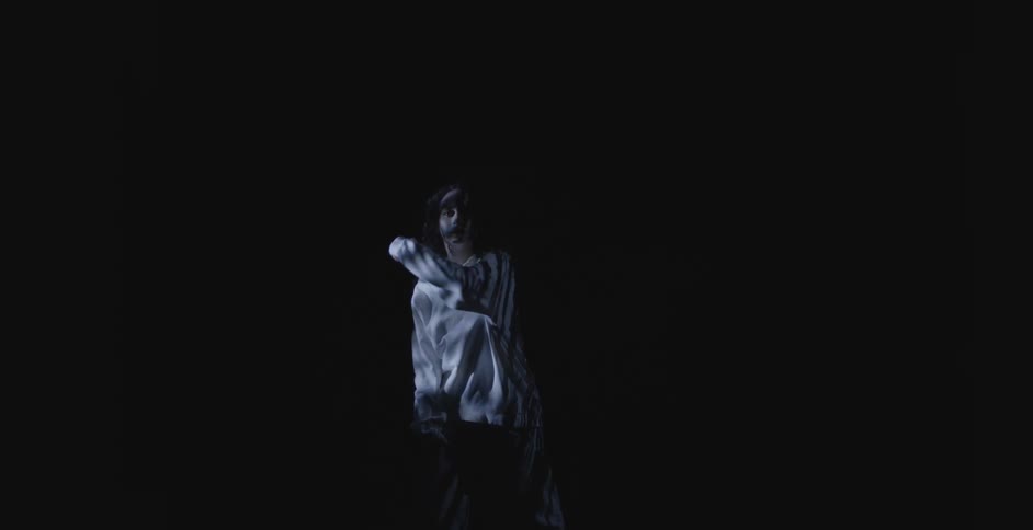 Woman dancing against a black background