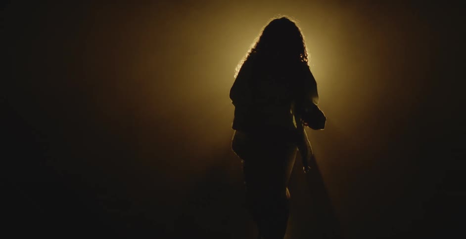 Silhouette of a performer dancing in front of a spotlight