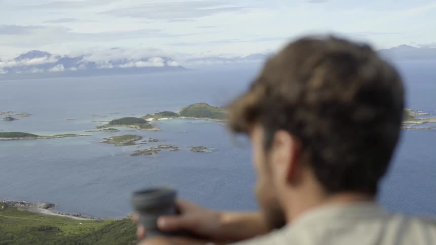A pensive adventurer appreciates the majestic beauty of nature during his mountain trek.