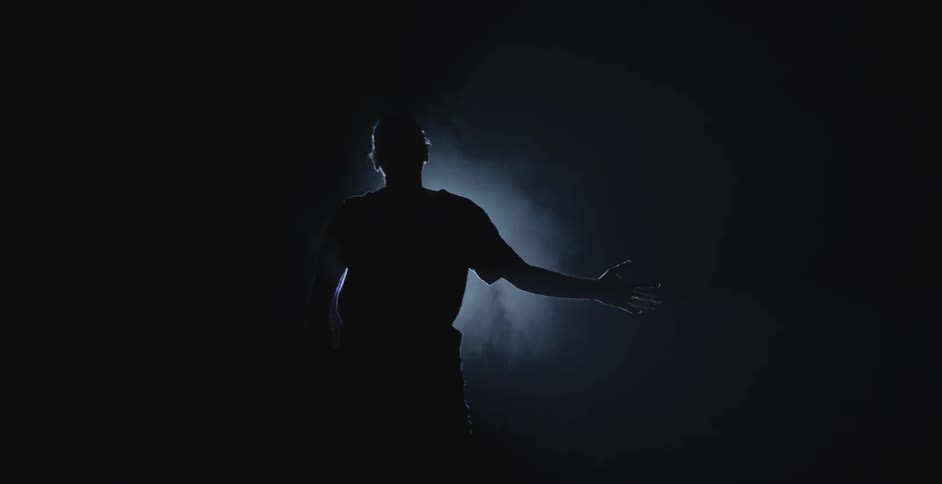 A man is dancing in front of a spotlight