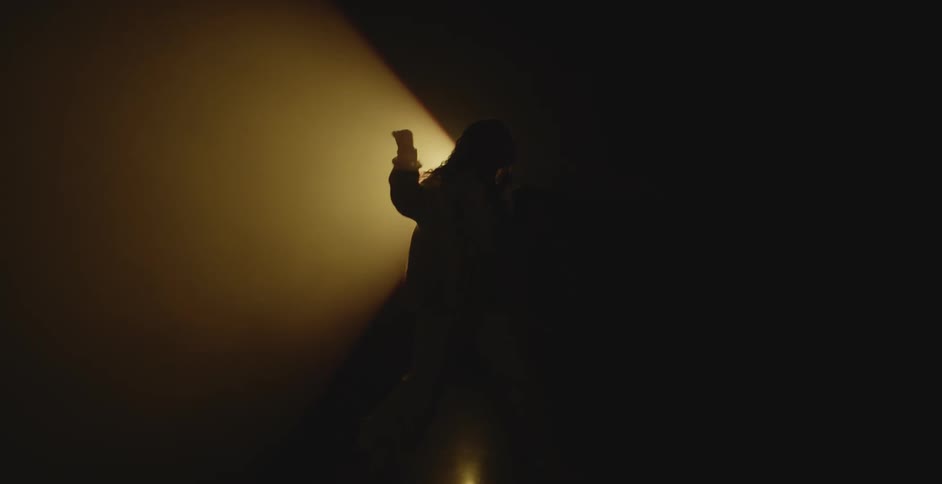 Silhouette of a couple dancing in front of a spotlight