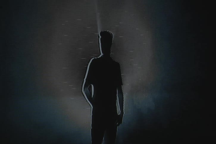 A man stands in the shadows