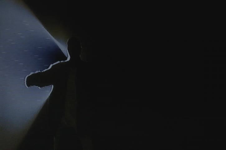 Silhouette of a man dancing in front of a spotlight