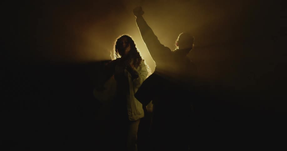 Silhouette of a couple dancing in front of a spotlighttion
