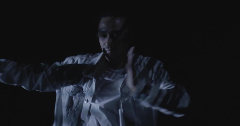 A man is dancing in the dark