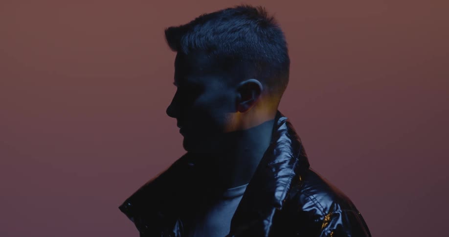 A man posing in a leather jacket at a photo shoot