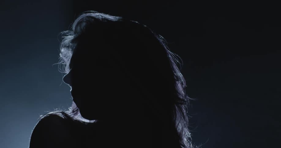 Silhouette of a woman in front of a spotlight