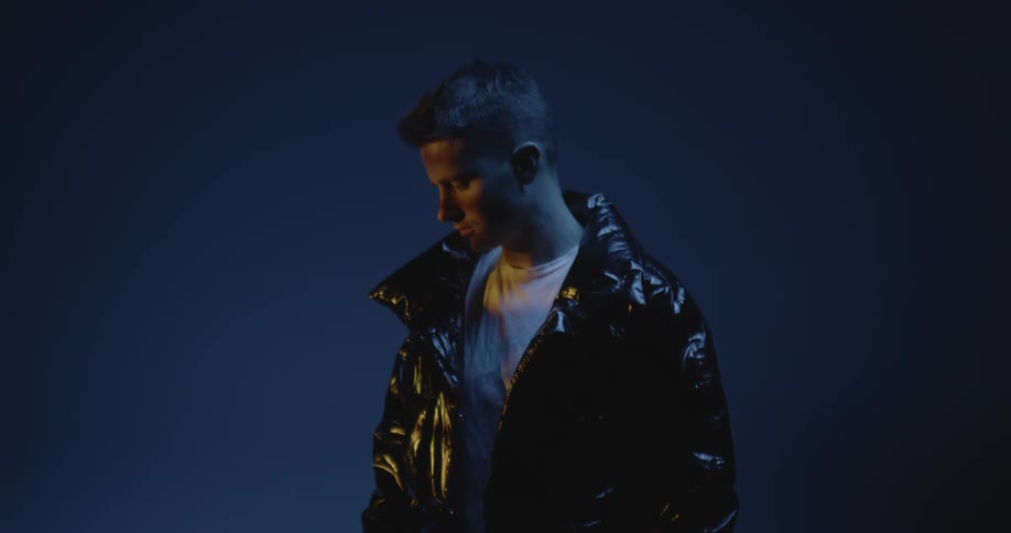 Young man modeling a jacket under moving lights