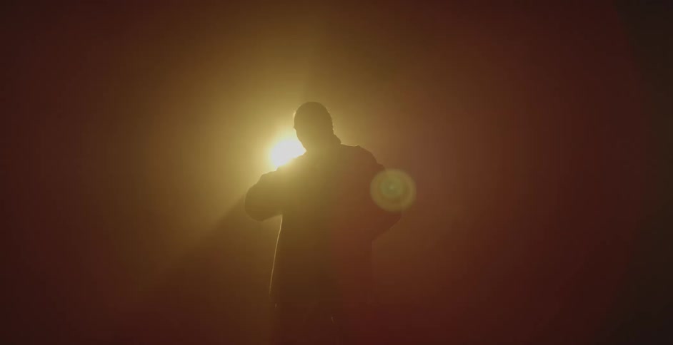 A man dances in front of the moving spotlight