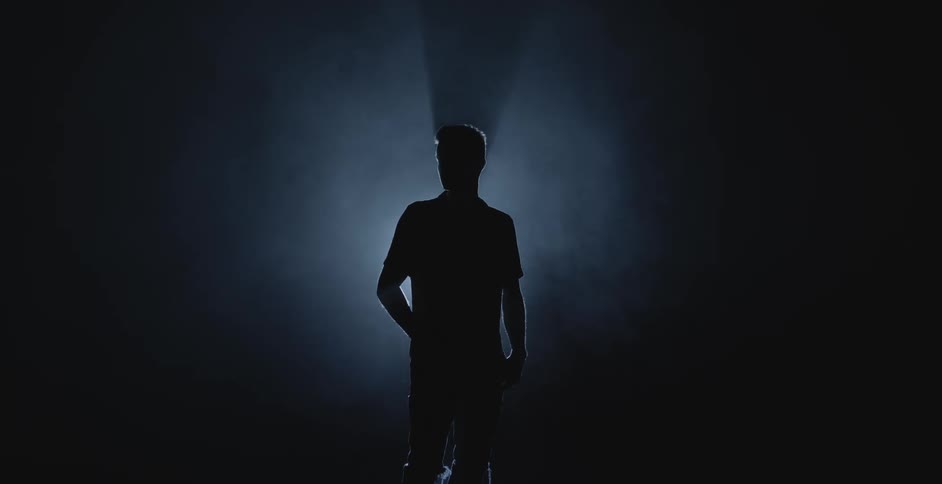 Silhouette of a man in front of a spotlight