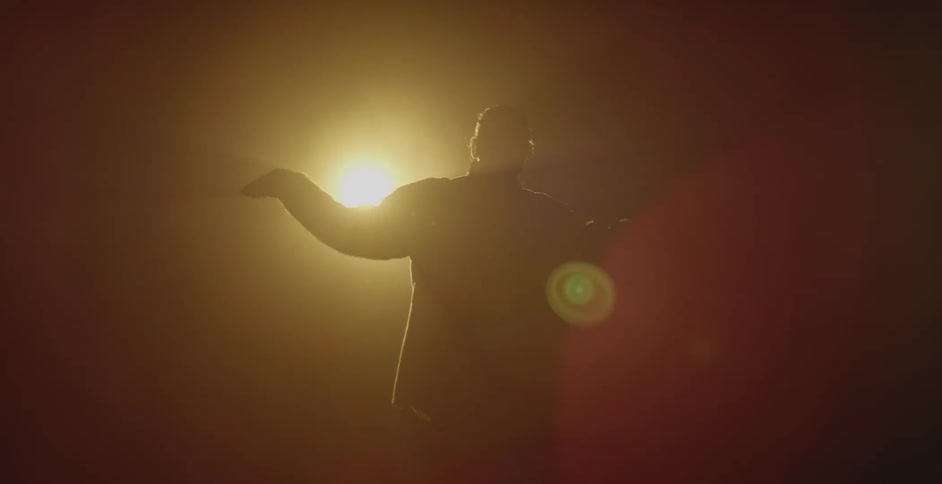 Silhouette of a man dancing in front of a spotlight