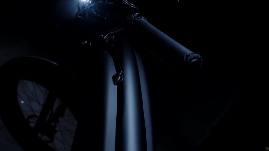 Handlebar of a black bicycle in a dark room