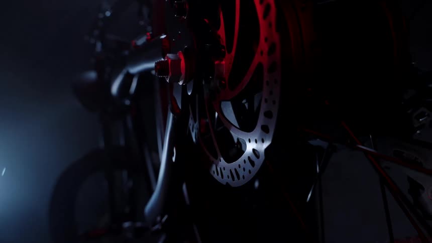 Close up of bicycle gears under red and white light