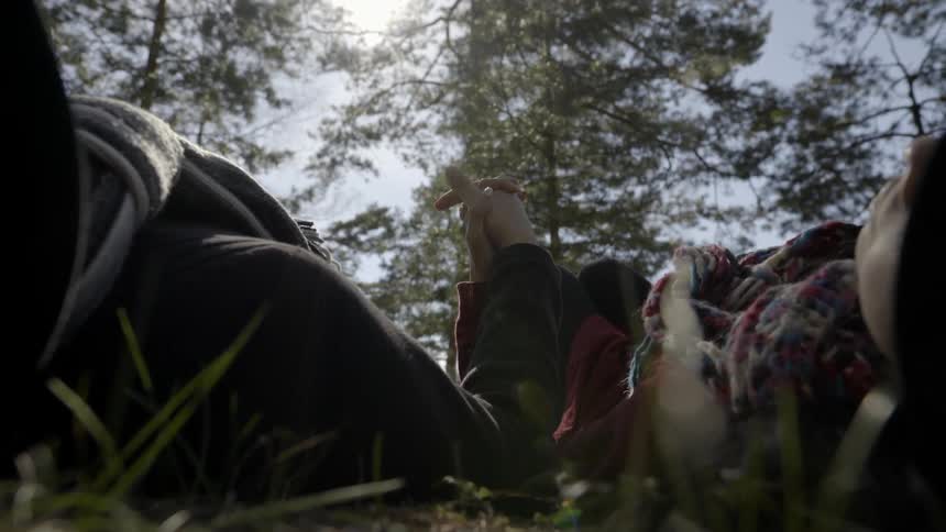 a man and woman connecting while relaxing in nature outdoors.