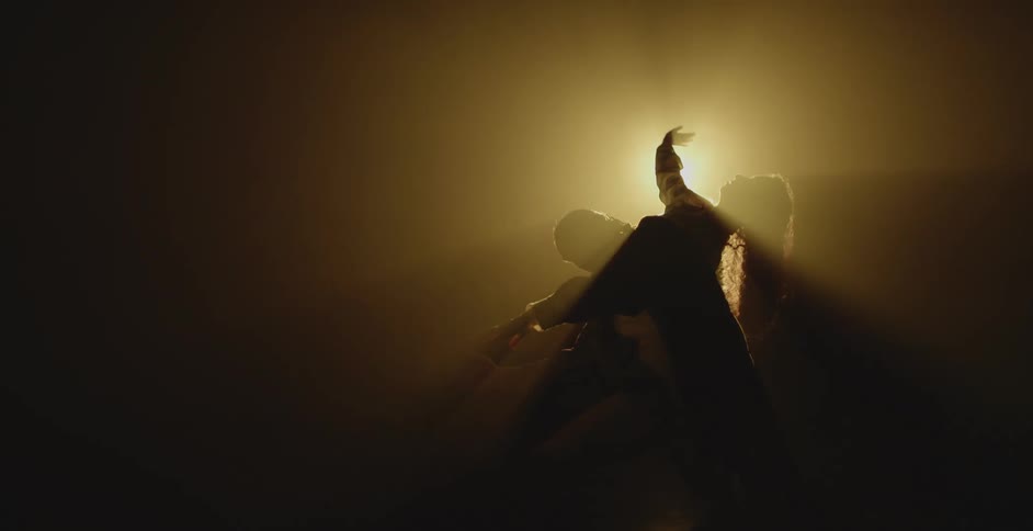 A man and woman dance before the spotlight