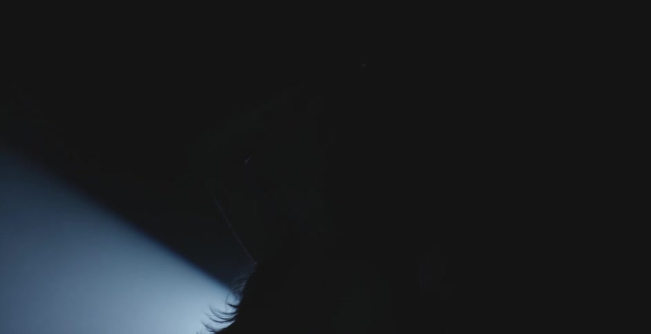 Silhouette of a woman in front of a spotlight