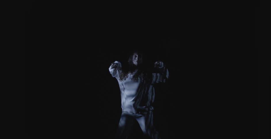 A dancer dancing in a dark room