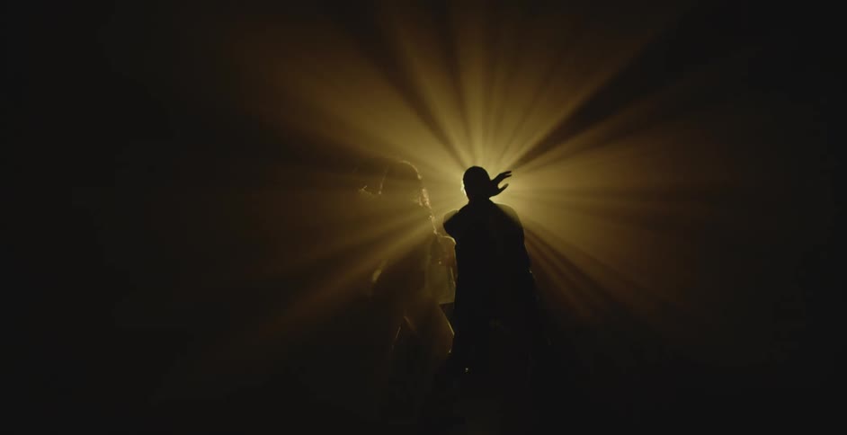 Silhouette of a couple dancing in front of a spotlight