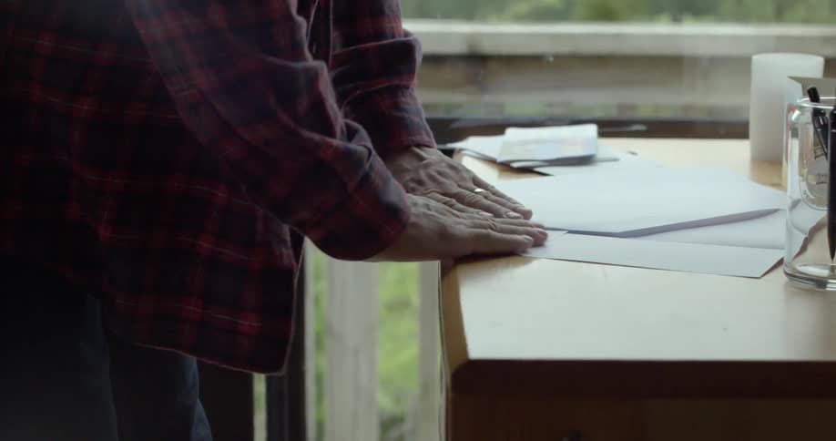 A person crafting a paper airplane during a peaceful afternoon outside.