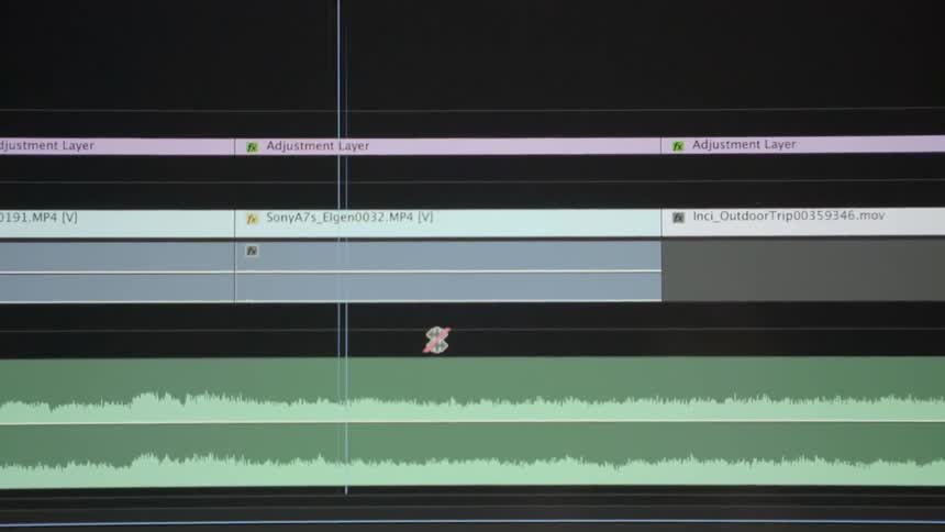 A professional content creator organizes media clips within post production software indoors.