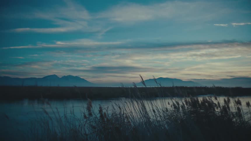 Panorama of the river with mountains on the horizon during dusk