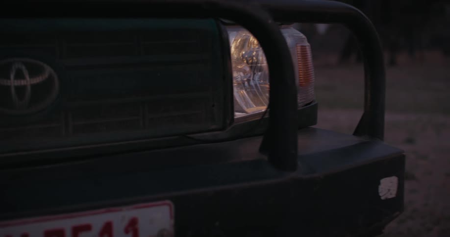Light from a car parked in nature during dusk