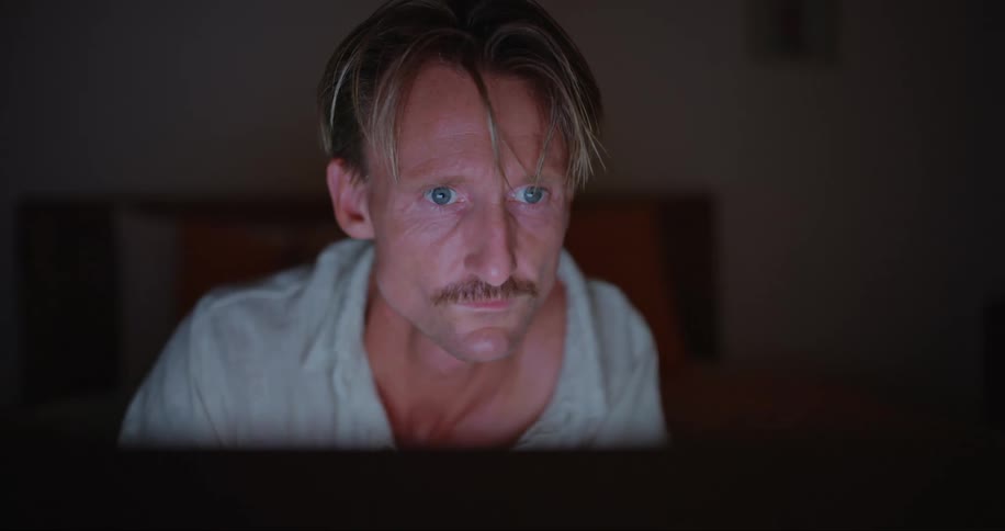A man concentrates as he looks upon the screen of his computer