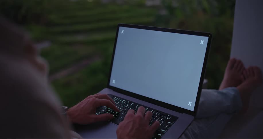 Ma sitting on the windowsill works on a laptop with a replaceable screen