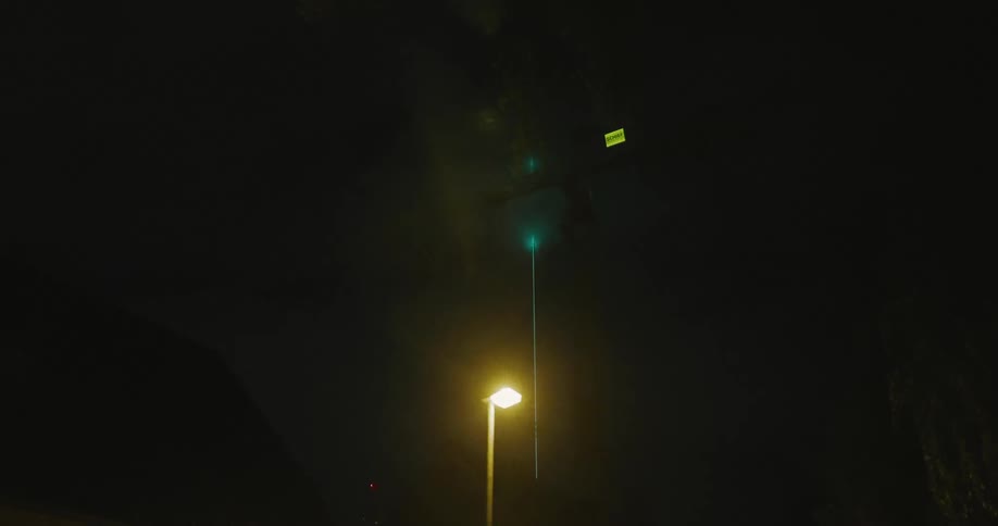 Green laser shot at the clouds at night