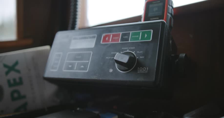 Hand turning the knob on a panel in a fishing boat