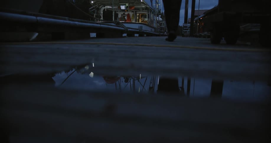 Reflection of a man walking on a pier