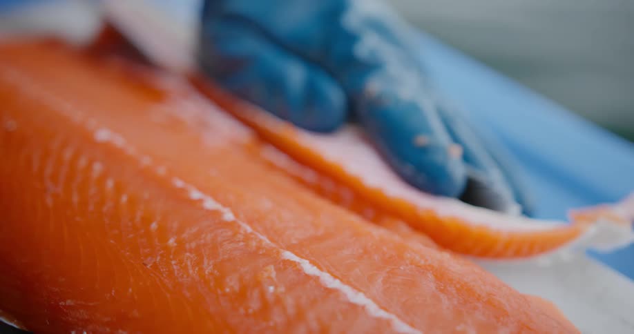 A person is cutting up salmon