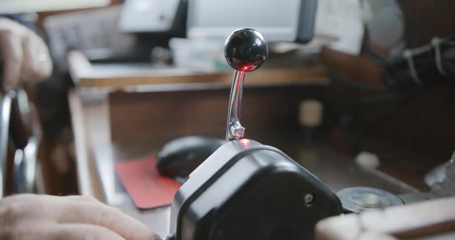 Captain of a small fishing boat pushes a lever in the cabin