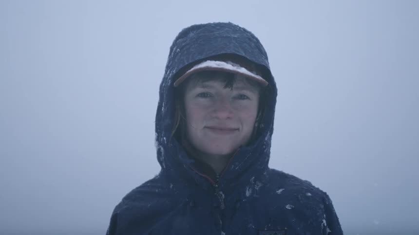 A smiling woman during a winter blizzard