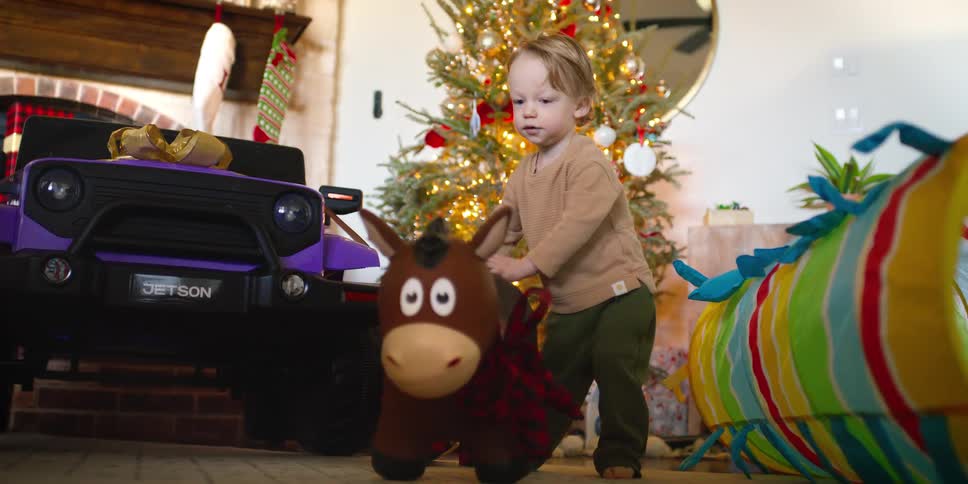 Boy playing with toys next to the christmas tree