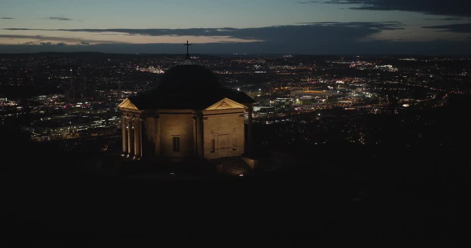 Skyline of an illuminated temple on top of a hill in urban city