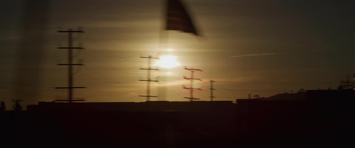 Sunset over a small town seen from a moving vehicle