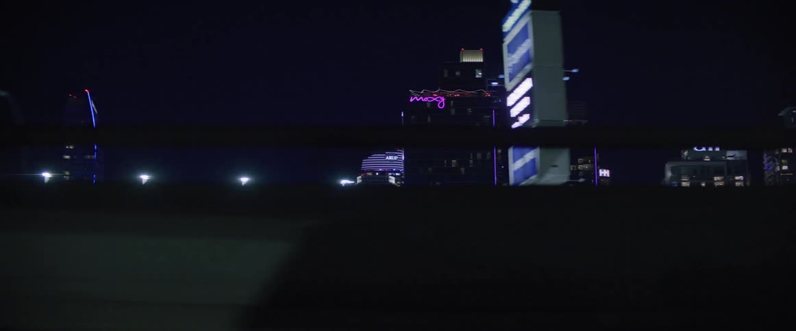 Skyline of a city at night seen from a moving vehicle