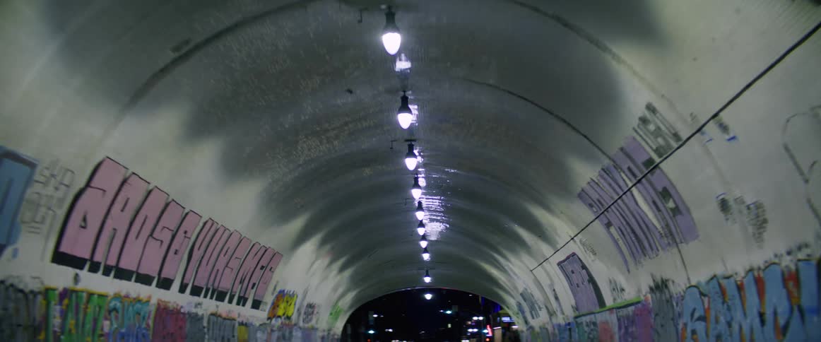 The interior of a concrete tunnel with graffiti walls