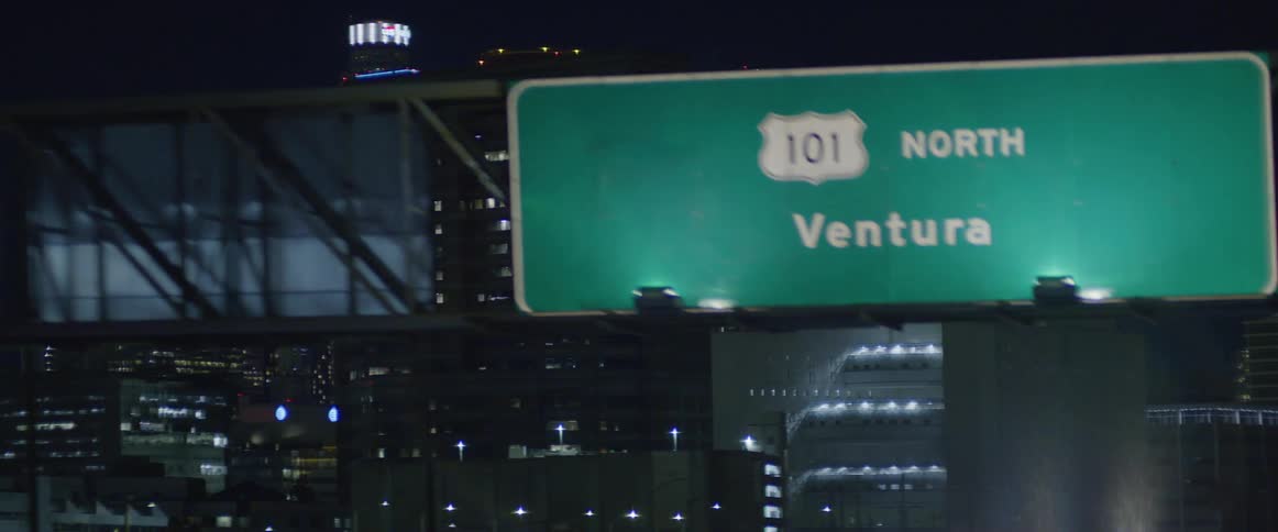 The city is brightly lit at night with many tall buildings