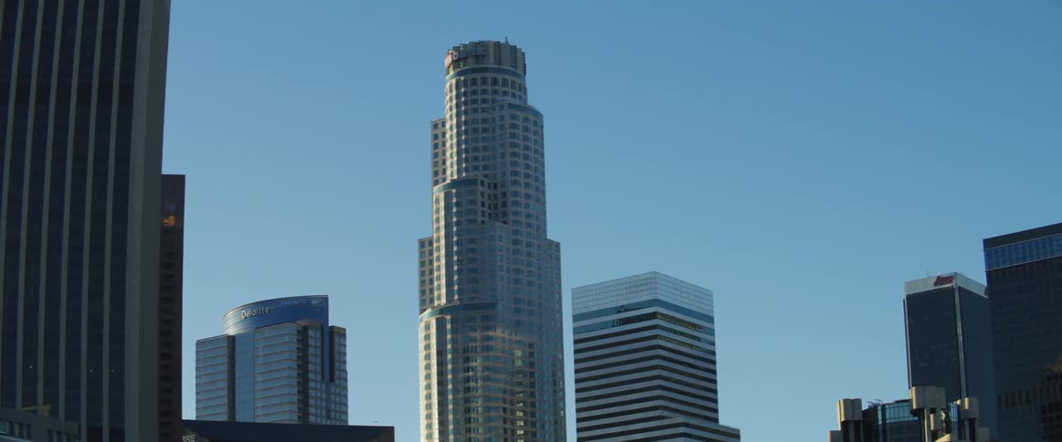 Multiple tall sky scrapers surround a metropolitan freeway in los angeles